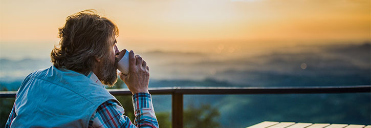 Man drinking coffee and watching the sunrise