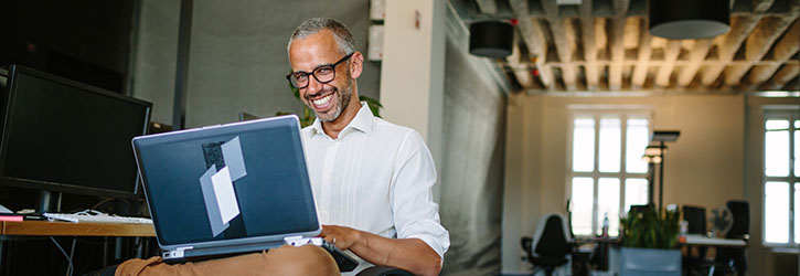 Business owner smiling on laptop