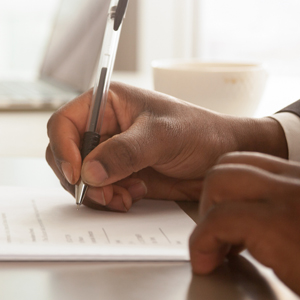 Man's hand signing mortgage documents