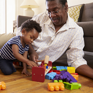 Grandfather and grandson playing on the floor